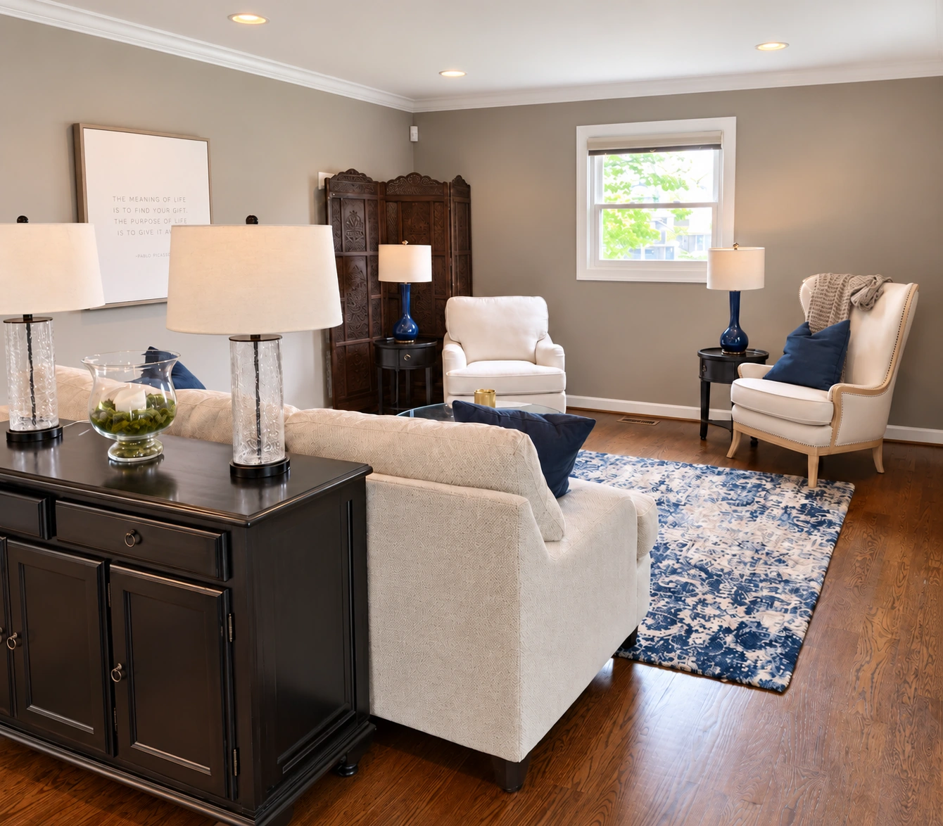 Living room painted by CHI, with gray walls, white trim and blue accents